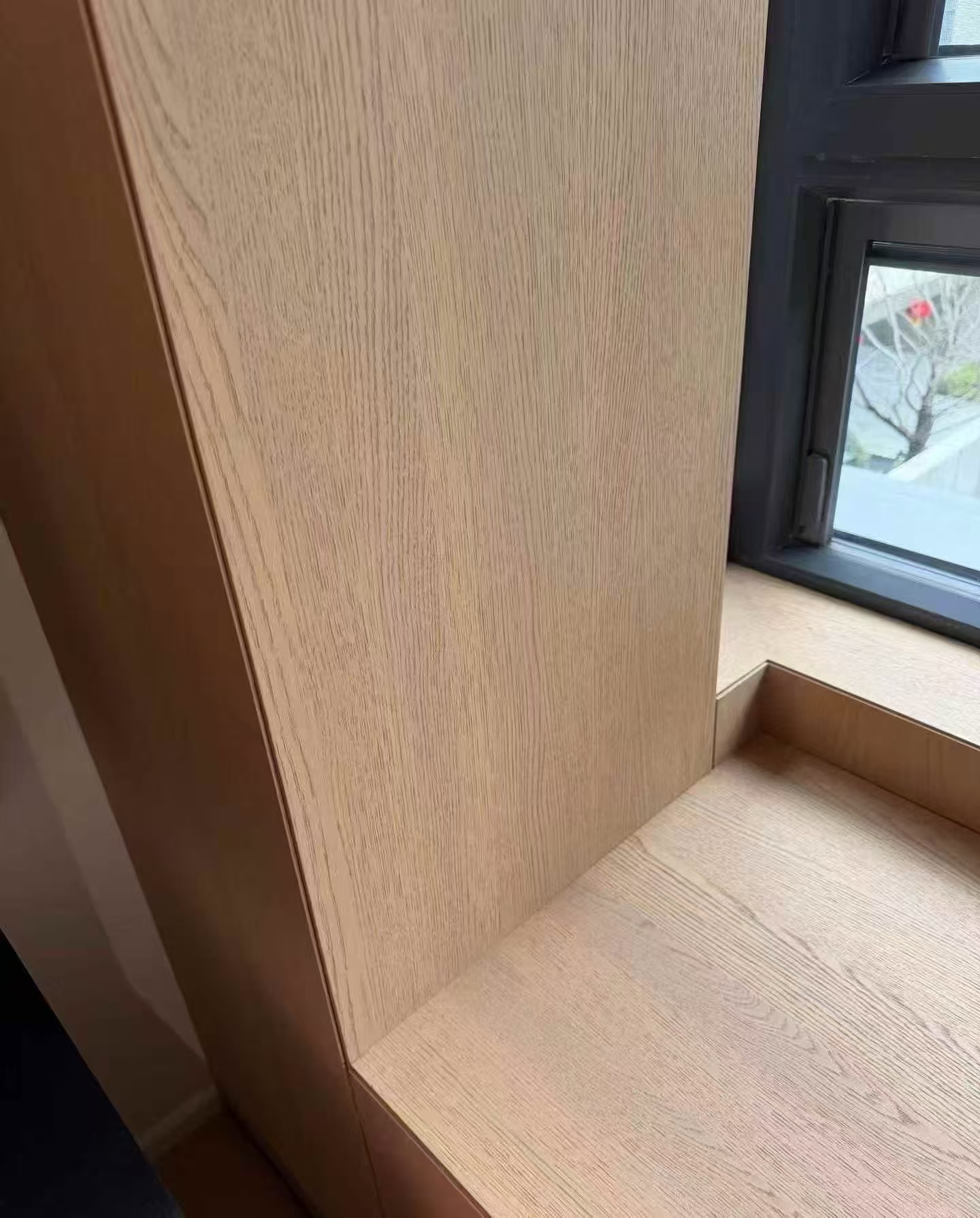 Mitred woodgrain wall-panel detail at a window reveal